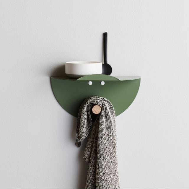 Wall-mounted, laser-cut circular metal shelf with a clothes hanger
