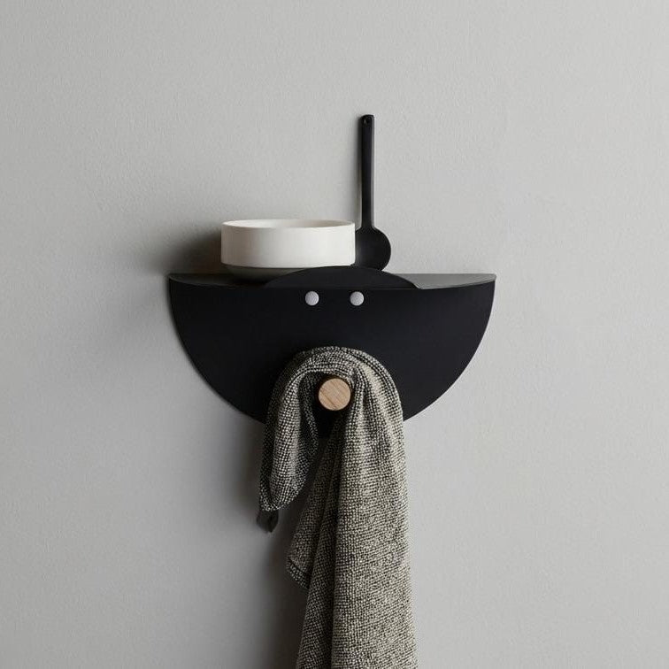 Wall-mounted, laser-cut circular metal shelf with a clothes hanger