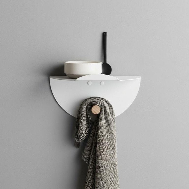 Wall-mounted, laser-cut circular metal shelf with a clothes hanger
